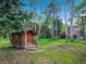 Exterior of a quaint log cabin shed on a lush green lawn surrounded by mature aspen trees at 2654 Sinton Rd, Evergreen, CO 80439