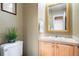 Powder room with light wood vanity and a large mirror at 12444 Knox Ct, Broomfield, CO 80020