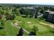 Aerial view of the golf course featuring manicured greens, sand traps and condo buildings at 13606 E Bates Ave # 309, Aurora, CO 80014