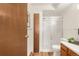 Bright bathroom featuring a walk-in shower with a glass door and wood style cabinets at 13606 E Bates Ave # 309, Aurora, CO 80014