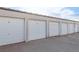 Multiple single garages with white doors provide secure parking for each tenant at 13606 E Bates Ave # 309, Aurora, CO 80014