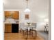 A kitchen with a dining table, light cabinets, and black appliances at 13606 E Bates Ave # 309, Aurora, CO 80014