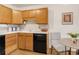The kitchen has wood cabinets, black appliances, and white countertops at 13606 E Bates Ave # 309, Aurora, CO 80014