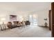 Bright living room with neutral tones, carpet, and a balcony entrance at 13606 E Bates Ave # 309, Aurora, CO 80014