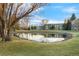 Scenic view of a pond with rock borders, trees, and community buildings in the background at 13606 E Bates Ave # 309, Aurora, CO 80014