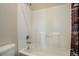 Full bathtub and shower with white wall surround and neutral fixtures at 749 Westward Ln, Palmer Lake, CO 80133