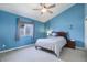 Comfortable bedroom featuring blue walls, carpet, and a ceiling fan at 749 Westward Ln, Palmer Lake, CO 80133