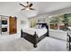 Bright bedroom featuring a ceiling fan and a large windows with a view of the lush yard at 10388 Lions Path, Lone Tree, CO 80124