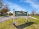 Entrance to the Wildcat Ridge community center with manicured lawns and mature trees under a bright sky at 10388 Lions Path, Lone Tree, CO 80124