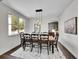 A dining room featuring dark hardwood floors, seating for eight, and a modern chandelier at 10388 Lions Path, Lone Tree, CO 80124
