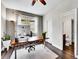 Well-lit home office with hardwood floors, a large window, closet storage, and a view into the ensuite bathroom at 10388 Lions Path, Lone Tree, CO 80124