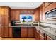 Kitchen with wooden cabinets, granite countertops, and stainless steel appliances at 12739 W Alabama Pl, Lakewood, CO 80228