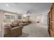 Cozy living room with plush carpeting, a ceiling fan, and bright windows for natural light at 12739 W Alabama Pl, Lakewood, CO 80228
