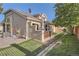 Backyard of stucco home with privacy fence and lush lawn at 2417 S Racine Way, Aurora, CO 80014