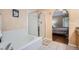Bathroom featuring a glass-enclosed shower, soaking tub, and archway to bedroom at 2417 S Racine Way, Aurora, CO 80014