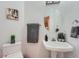 Cozy half bathroom featuring a round mirror, modern fixtures, and charming decor at 2417 S Racine Way, Aurora, CO 80014