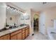 Bright bathroom featuring double sinks, granite countertops, and walk-in closet at 2417 S Racine Way, Aurora, CO 80014