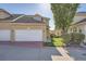 Charming stucco home boasts an attached two-car garage and manicured lawn at 2417 S Racine Way, Aurora, CO 80014