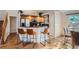 Kitchen with wooden cabinets, stainless steel appliances, bar seating, and an adjacent dining area at 2417 S Racine Way, Aurora, CO 80014