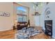 Bright living room featuring a fireplace, hardwood floors, and a comfortable leather sofa under large windows at 2417 S Racine Way, Aurora, CO 80014