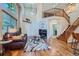 Open-concept living room featuring hardwood floors, a fireplace, and staircase at 2417 S Racine Way, Aurora, CO 80014