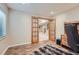 Downstairs office space with wood-look tile floor, a window for natural light, and an adjacent stairway at 2417 S Racine Way, Aurora, CO 80014