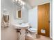 Bright bathroom with white pedestal sink, woven mirror, and neutral-toned towel at 4227 S Granby Ct # C, Aurora, CO 80014