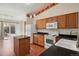 Kitchen with granite island, wood cabinets, and appliances at 7139 Pine Hills Way, Littleton, CO 80125