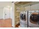 Laundry room with washer, dryer, and shelving for storage at 7139 Pine Hills Way, Littleton, CO 80125