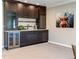 Finished basement bar area with custom cabinets, granite counters, and wine refrigerator at 2601 S Quebec St # 6, Denver, CO 80231