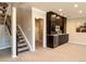 Finished basement area with a stylish bar and stairs leading to the upper level at 2601 S Quebec St # 6, Denver, CO 80231