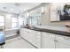 An elegant bathroom featuring white cabinetry, marble accents, and a standalone soaking tub at 2601 S Quebec St # 6, Denver, CO 80231