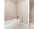 Clean bathroom with a white bathtub, light tile walls, and floors at 2601 S Quebec St # 6, Denver, CO 80231