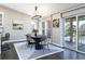 Bright dining room featuring a modern chandelier, sleek table, and sliding glass doors to the outdoor patio at 2601 S Quebec St # 6, Denver, CO 80231