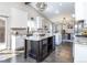 Open-concept kitchen features a large island, granite countertops, white cabinets, and stainless steel appliances at 2601 S Quebec St # 6, Denver, CO 80231
