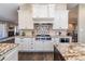 Elegant kitchen boasts white cabinets, granite countertops, stainless steel appliances, and a decorative backsplash at 2601 S Quebec St # 6, Denver, CO 80231