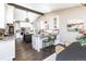Open kitchen with white cabinets, granite counters, a dark island with bar seating, and a beamed, vaulted ceiling at 2601 S Quebec St # 6, Denver, CO 80231