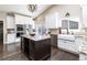 Well-appointed kitchen with a dark wood island, granite countertops, white cabinetry, and stainless steel appliances at 2601 S Quebec St # 6, Denver, CO 80231