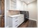 Well-lit laundry room with white cabinets, modern appliances, and a convenient sink at 2601 S Quebec St # 6, Denver, CO 80231