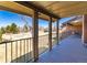 A covered patio with wood decking, metal railings, and a beautiful view of the open outdoor area at 2601 S Quebec St # 6, Denver, CO 80231