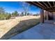 Back patio area with a view of a large backyard with trees at 2601 S Quebec St # 6, Denver, CO 80231