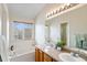 Bright bathroom featuring double sinks, a soaking tub, and a large window at 8335 Deframe Ct, Arvada, CO 80005