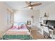 Bright bedroom featuring a ceiling fan, desk, and a cozy bed with soft pillows and a decorative throw at 8335 Deframe Ct, Arvada, CO 80005