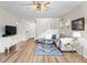 Bright living room featuring a modern entertainment center and hardwood floors at 8335 Deframe Ct, Arvada, CO 80005