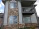 Two-story condo featuring stone accents, a balcony, large windows, and neutral siding at 3271 E 103Rd Pl # 1307, Thornton, CO 80229