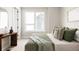 Cozy bedroom with a wooden console table, a large window, and a comfortable bed with patterned pillows at 8280 E 36Th Ave # 26, Denver, CO 80238
