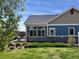 Home exterior featuring a well-maintained lawn, stone accents, and a cozy outdoor patio area for relaxing at 12604 Madison Way, Thornton, CO 80241