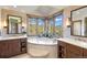 Bright bathroom featuring double vanity sinks, large soaking tub, and picturesque window view at 23 Verde Ct, Breckenridge, CO 80424