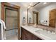 Bathroom featuring double sinks with elegant countertops and cabinets and a glass enclosed shower/tub combination at 23 Verde Ct, Breckenridge, CO 80424