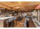 Open concept kitchen with breakfast bar leading to living and dining spaces; wooden floors and beams at 23 Verde Ct, Breckenridge, CO 80424
